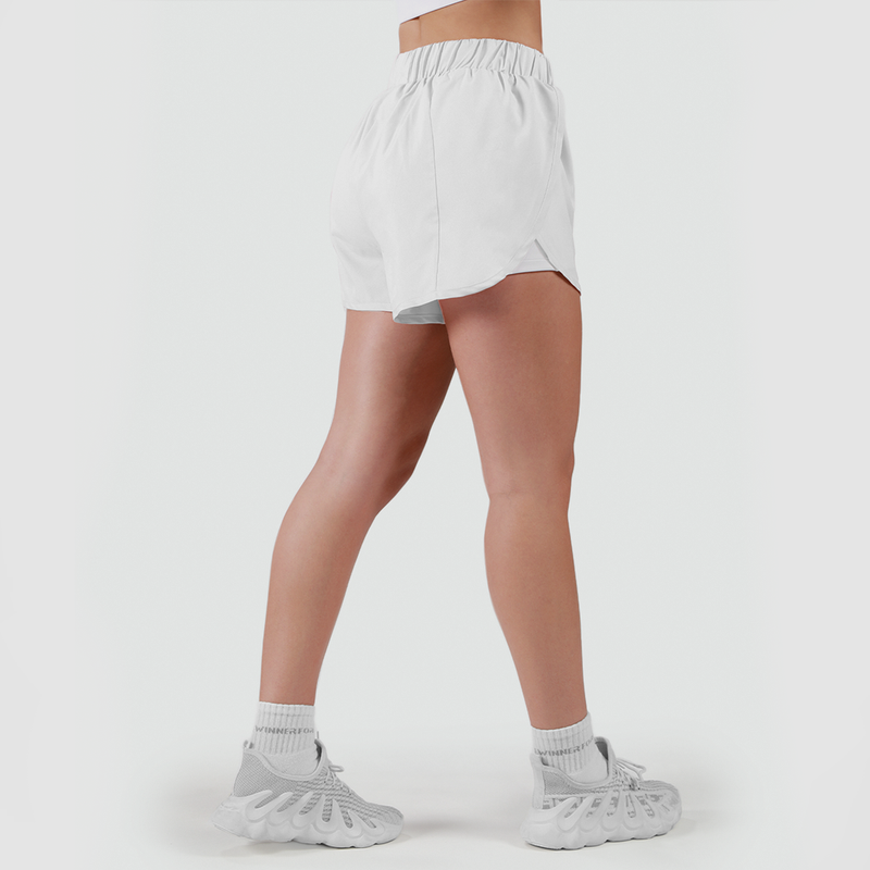 a fit woman stand at right and wearing short  white with shoes white ,plus the background is light grey 
