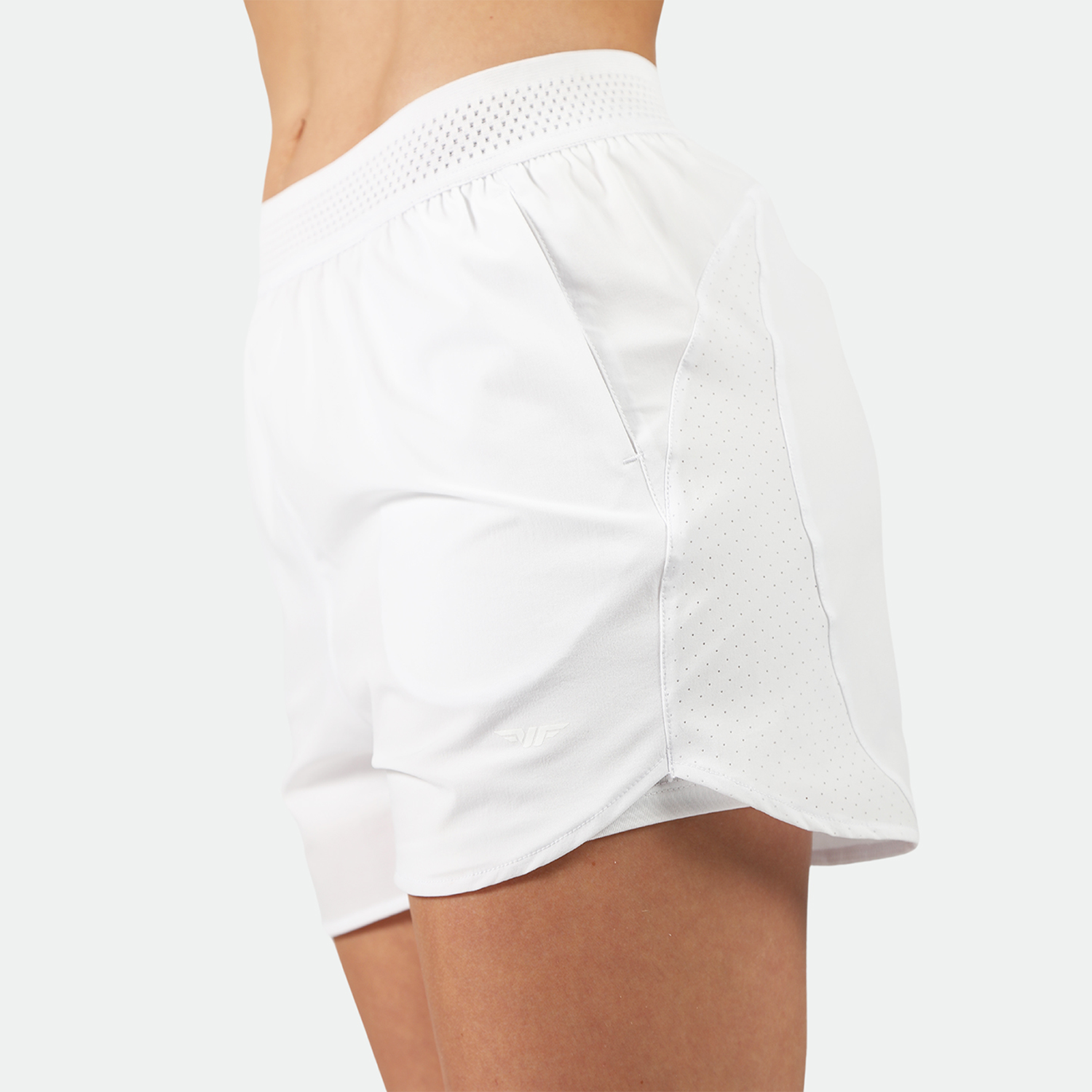 a fit woman stand at right and wearing short white 2 in 1 with logo ,plus the background is light grey 