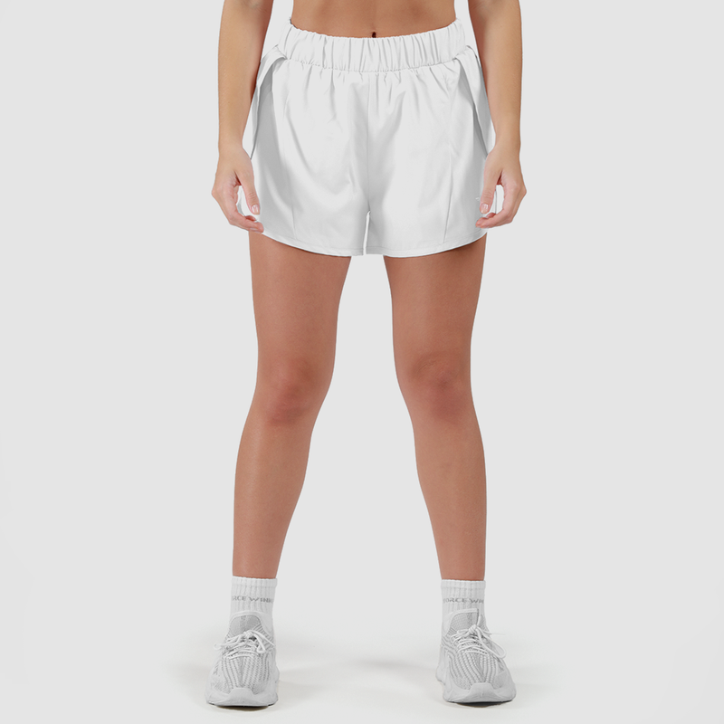 a fit woman wearing short white 2 in 1 with shoes  white ,plus the background is light grey 