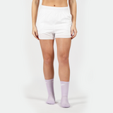 a fit woman wearing short white 2 in 1 with socks purpel ,plus the background is light grey 
