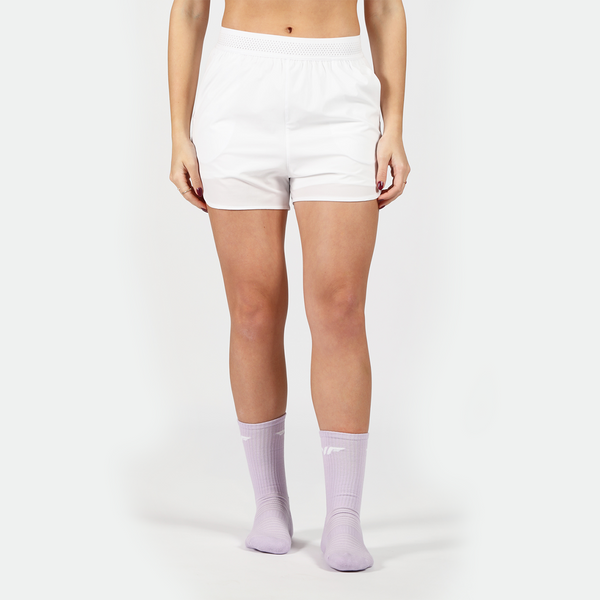 a fit woman wearing short white 2 in 1 with socks purpel ,plus the background is light grey 