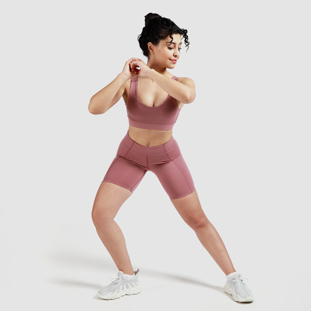 a women  wearing  matching bra and short with background light grey 