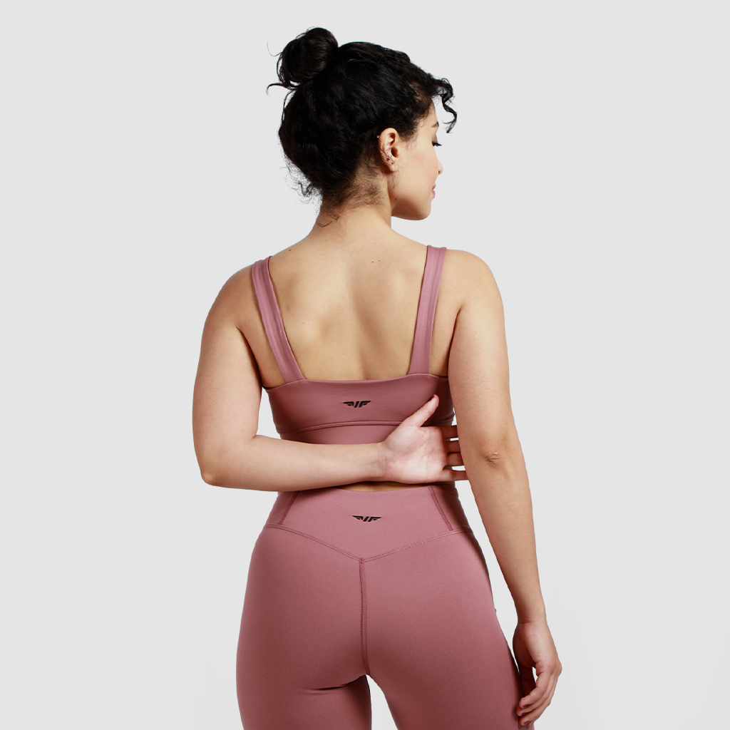 a back view for woman  wearing matching bra and legging have same logo with background light grey