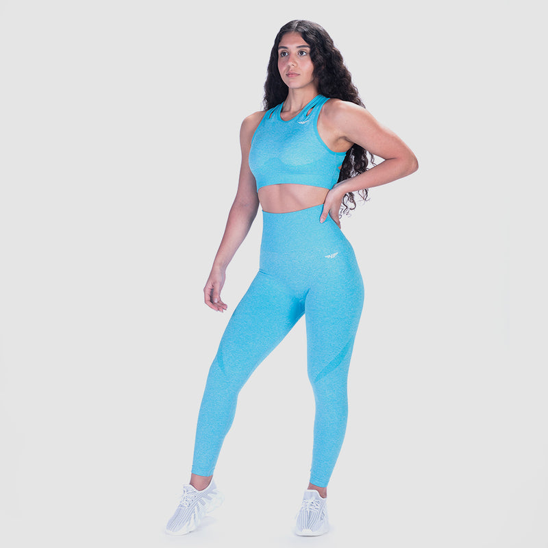 a fit woman wearing matching bra and legging blue with logo ,and she wearing  shoes white ,the background is light grey 