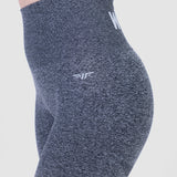 a fit woman wearing legging grey with logo , and the background is light grey 