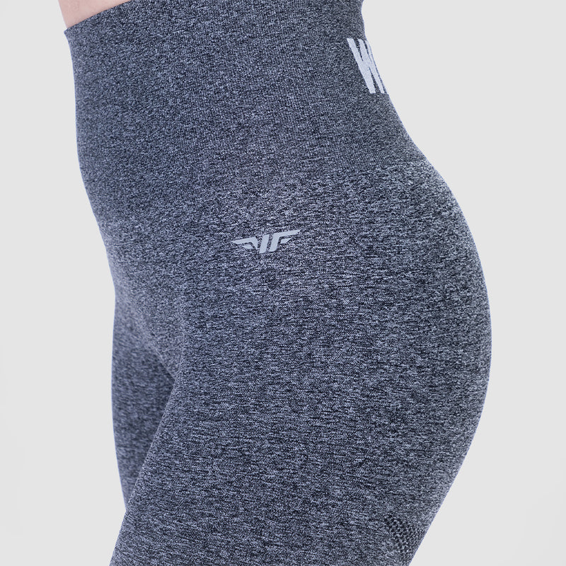 a fit woman wearing legging grey with logo , and the background is light grey 