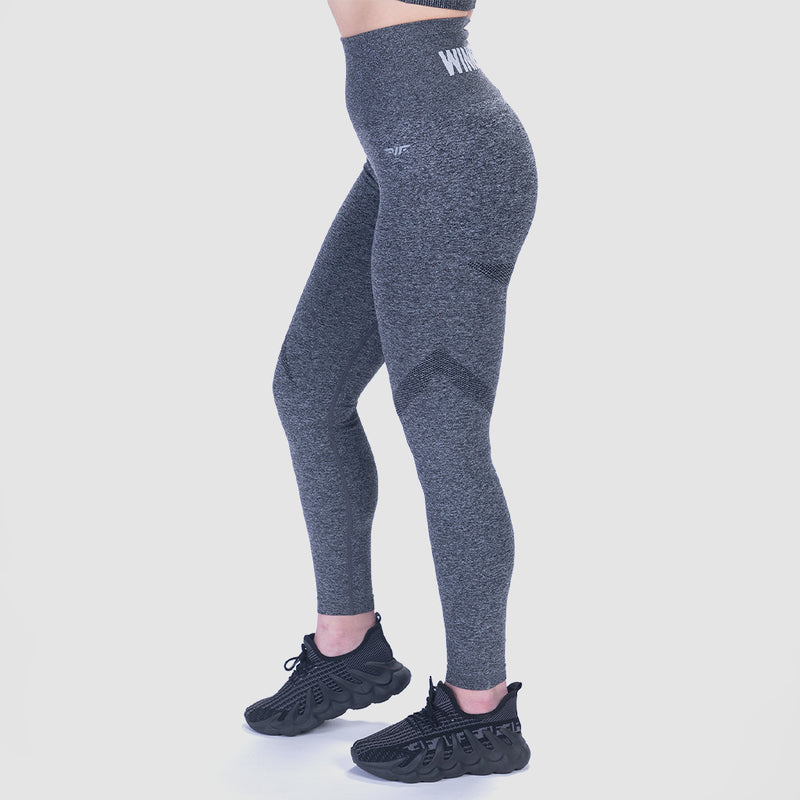 a woman stand at right  and wearing legging grey and shoes black ,plus the background is light grey 