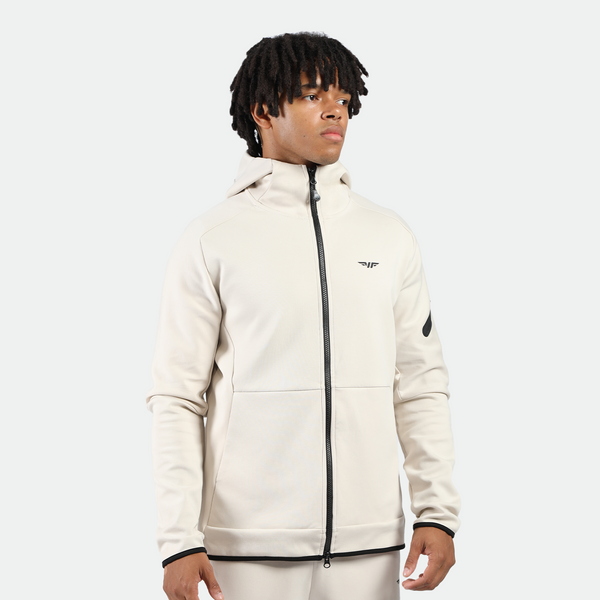 a fit man wearing matching set  light beige ,tech zipped hoodie with pants 