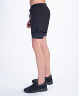 a fit man stand at right and wearing short 2 in 1 with shoes black 