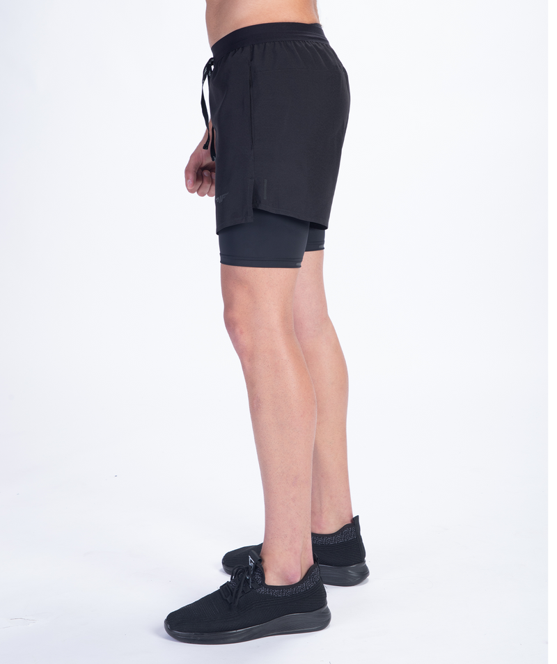 a fit man stand at right and wearing short 2 in 1 with shoes black 