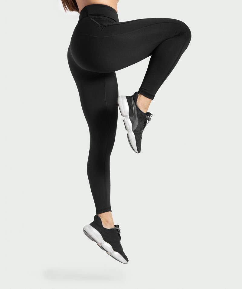  a woman wearing legging push up with shoes black ,plus the background is light grey 