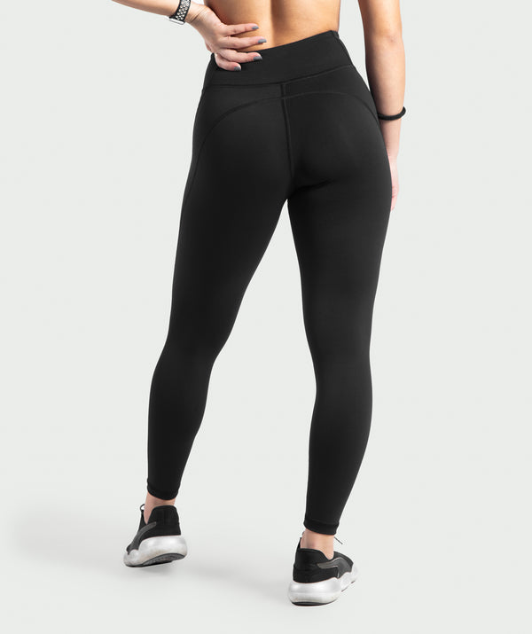 a back view for woman wearing high wasited legging morocco and shoes black ,plus background is light grey 